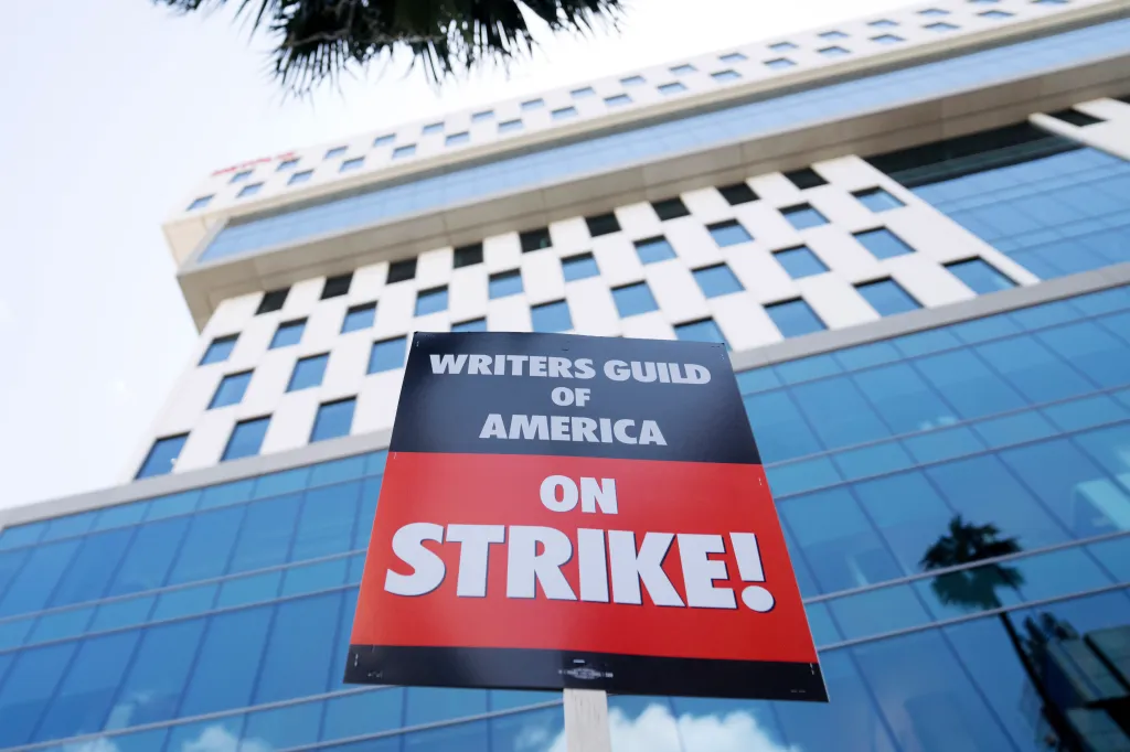 Featured image for Hollywood CEOs profit as WGA strike impacts TV and movies.