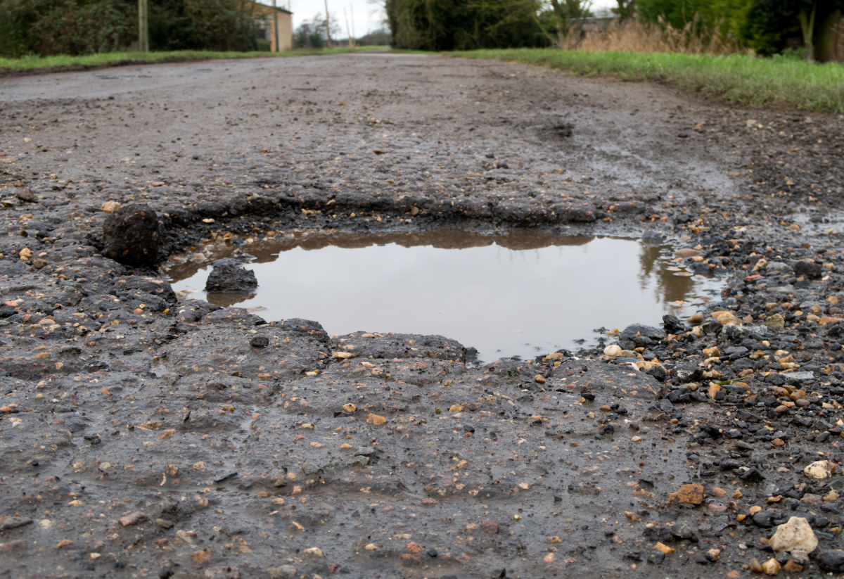 Featured image for Pothole Enlarges and Traps Car in Its Grasp