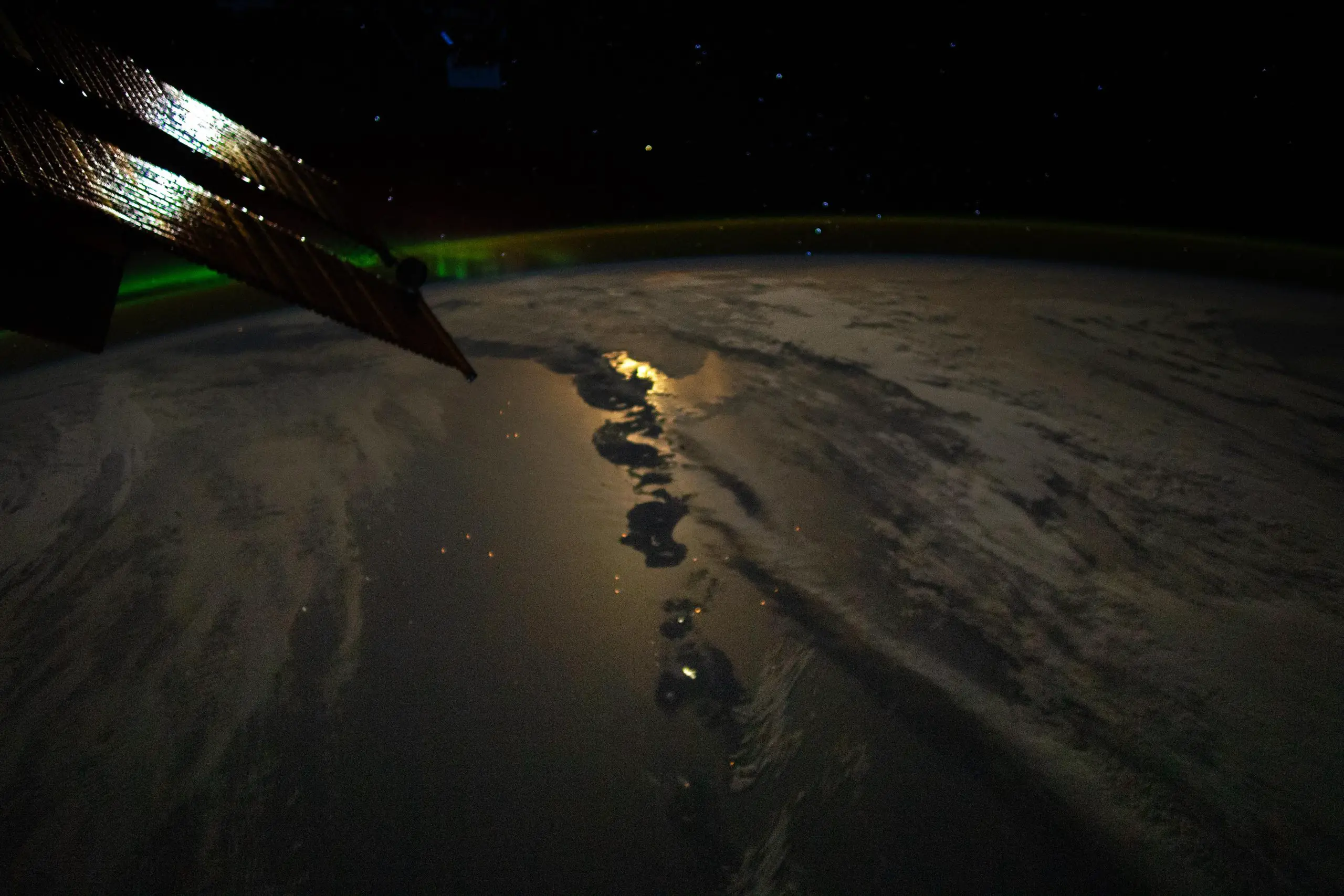 "Astronaut's Spectacular View: Moonglint, Volcanic Aleutians, and Aurora Borealis"