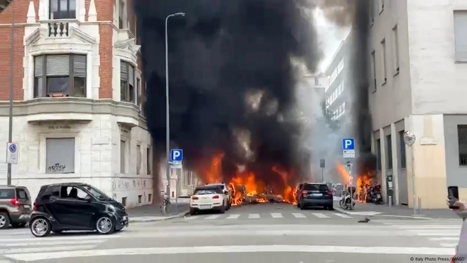 Explosion rocks central Milan, injuring one and setting vehicles ablaze.