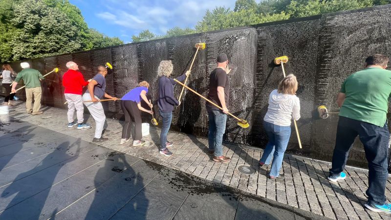 Bipartisan group honors Vietnam Veterans Memorial with hand-washing and clean-up.