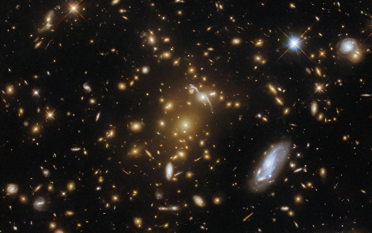 Featured image for Hubble captures stunning image of massive galaxy cluster.